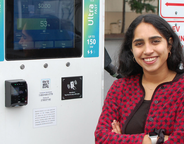 Civil and environmental engineering graduate student Rubina Singh stands next to an EV charging station